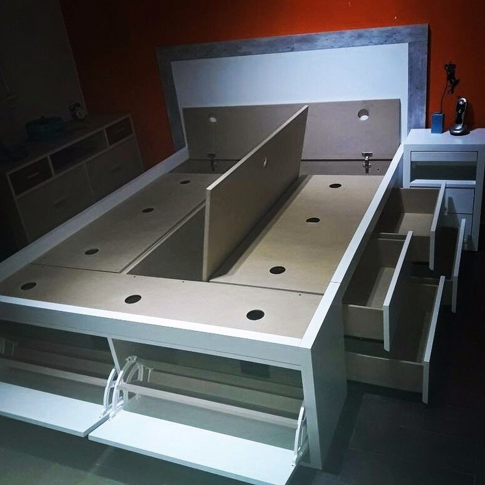 Выдвижные ящики в два ряда вдоль двух боков кровати, обувницы с откидными дверками в изножье, центральная часть и часть около изголовья закрываются откидными щитами